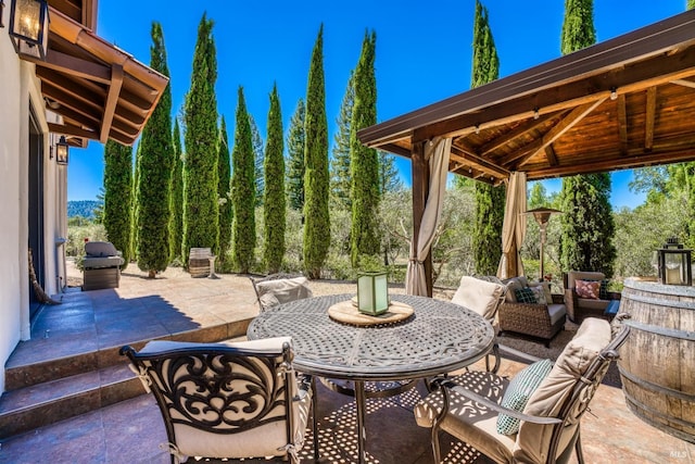 view of patio with a gazebo, outdoor dining area, and a grill