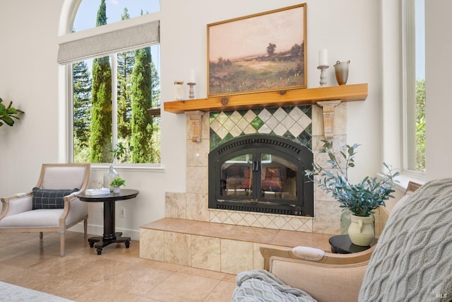 living area with light tile patterned floors, baseboards, and a tile fireplace