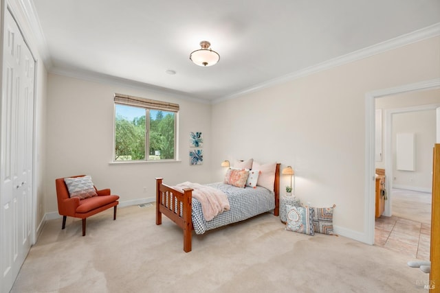 bedroom featuring ornamental molding, a closet, light carpet, and baseboards