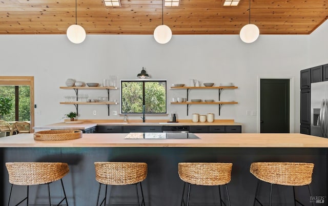 kitchen featuring open shelves, a sink, wooden ceiling, wooden counters, and hanging light fixtures