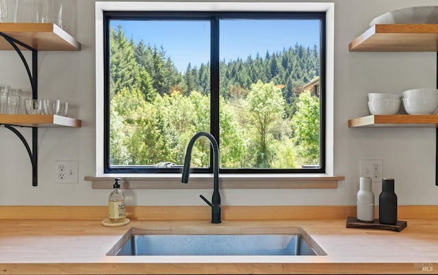 kitchen with a sink, open shelves, and light countertops