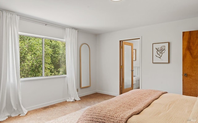 bedroom featuring visible vents, ensuite bath, and baseboards