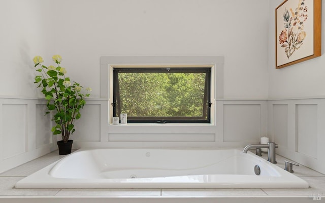 full bath featuring a decorative wall and a garden tub