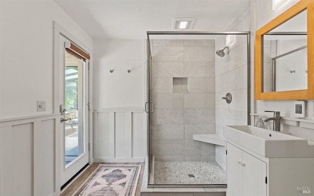 full bathroom featuring wainscoting, a shower stall, and vanity