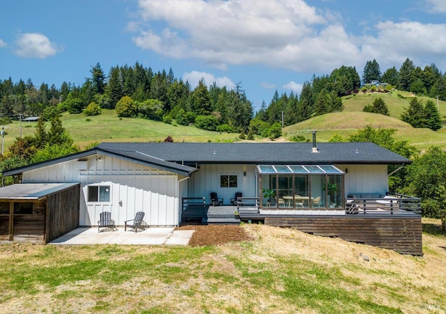 rear view of house featuring a lawn and a patio