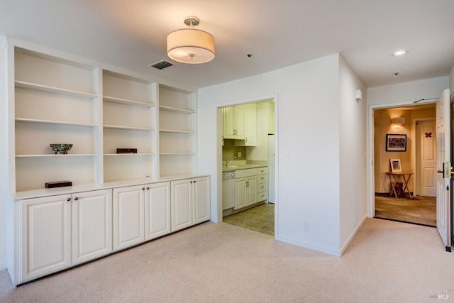 unfurnished living room featuring light colored carpet and sink