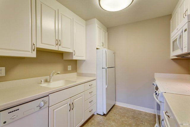 kitchen with white appliances, white cabinetry, and sink