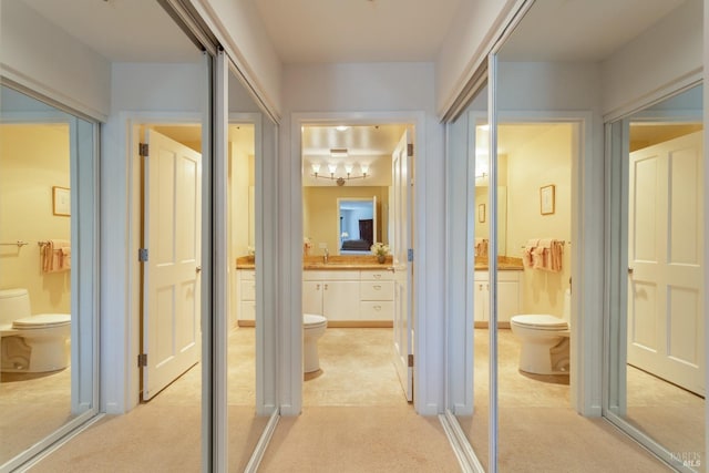 hall with sink and light colored carpet