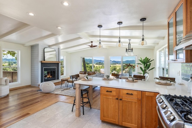 kitchen featuring vaulted ceiling with beams, a wealth of natural light, light hardwood / wood-style flooring, and decorative light fixtures