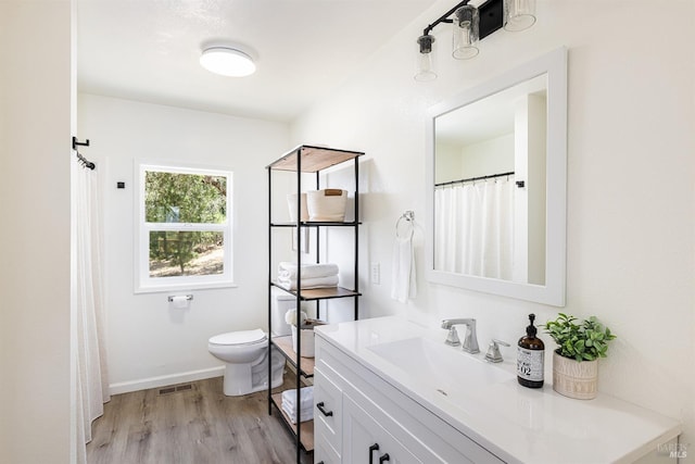 bathroom featuring wood-type flooring, vanity, and toilet