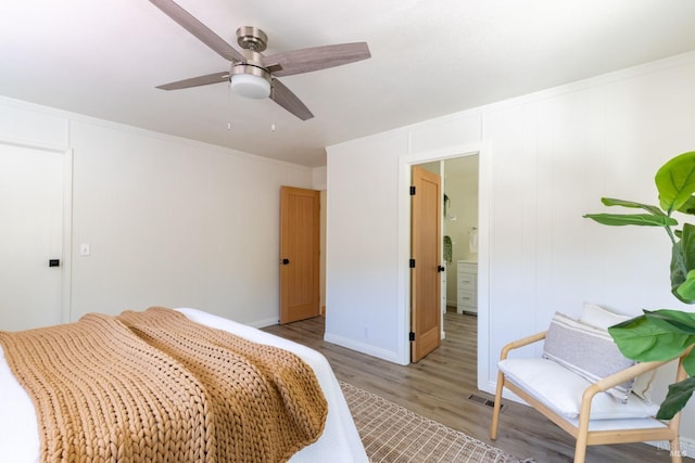 bedroom featuring crown molding, ceiling fan, ensuite bathroom, and light hardwood / wood-style floors