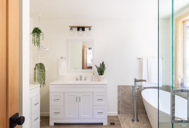 bathroom featuring a washtub, vanity, and hardwood / wood-style flooring