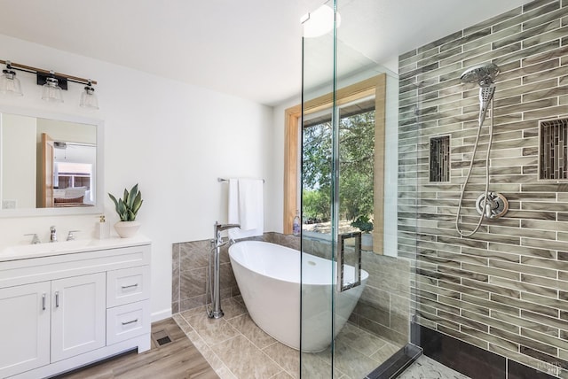 bathroom featuring a washtub, wood-type flooring, and vanity