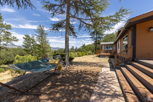 view of yard with a deck with mountain view