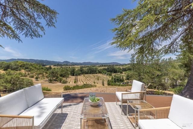 view of patio / terrace with outdoor lounge area, a mountain view, and a rural view