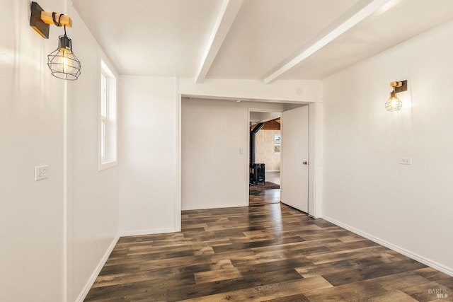 corridor featuring beam ceiling and dark hardwood / wood-style flooring