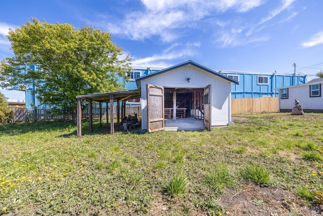 rear view of house featuring a lawn and a shed