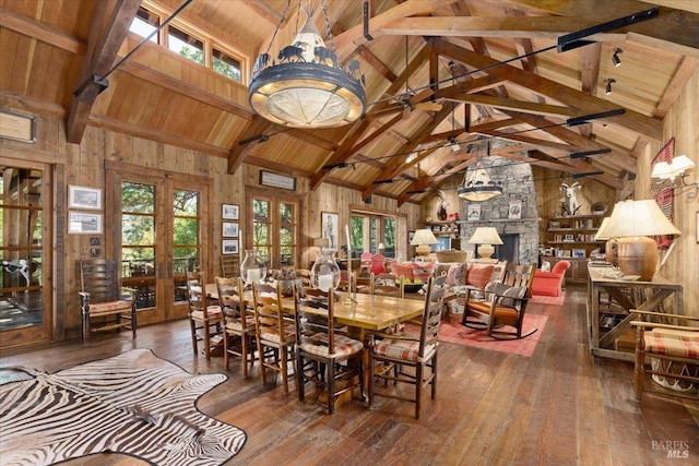 dining area featuring beam ceiling, a wealth of natural light, hardwood / wood-style flooring, and wood ceiling