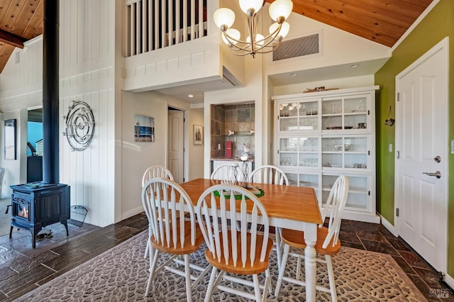 dining area with wood ceiling, high vaulted ceiling, a chandelier, and a wood stove