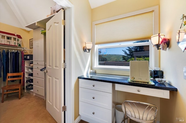 home office featuring built in desk and light colored carpet