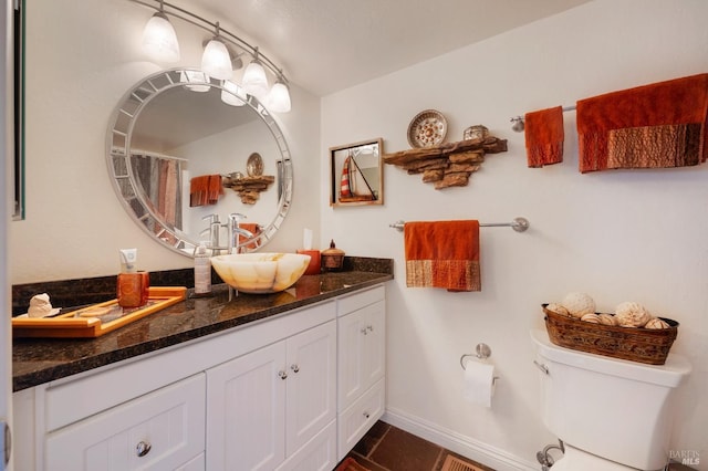 bathroom featuring vanity, tile patterned floors, and toilet