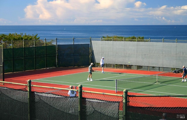 view of sport court with a water view