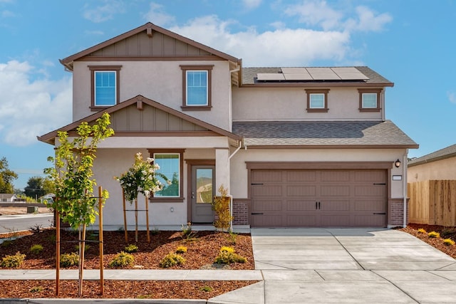 view of front of home featuring brick siding, roof mounted solar panels, driveway, and fence