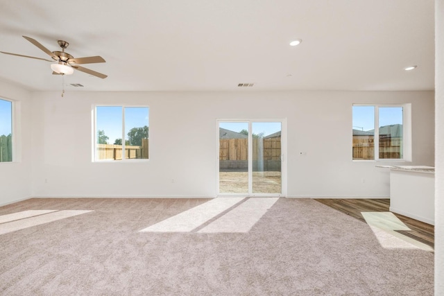 unfurnished living room featuring visible vents, recessed lighting, carpet, and baseboards