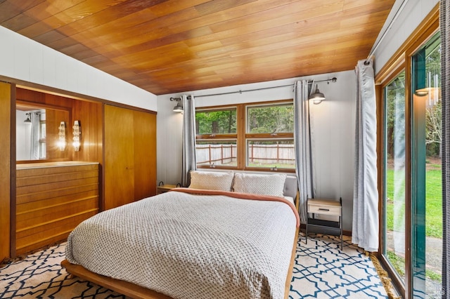 bedroom featuring lofted ceiling, multiple windows, and wood ceiling