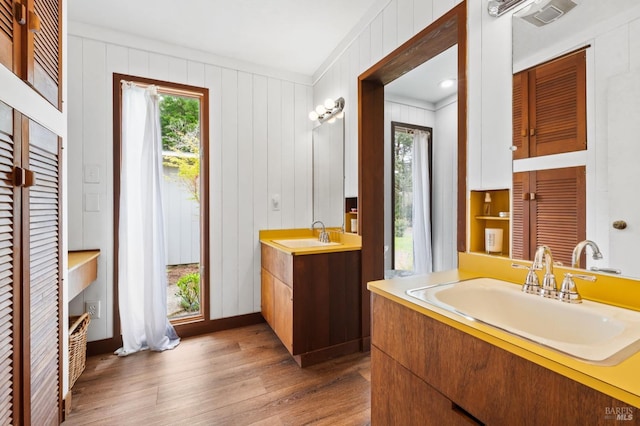 bathroom with crown molding, vanity, a healthy amount of sunlight, and hardwood / wood-style flooring