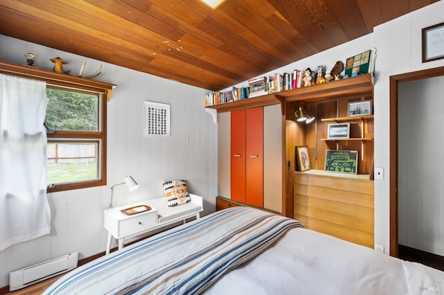 bedroom featuring a baseboard heating unit, wood walls, and wood ceiling