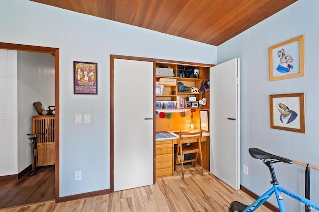 interior space with wood ceiling, built in desk, and light hardwood / wood-style flooring