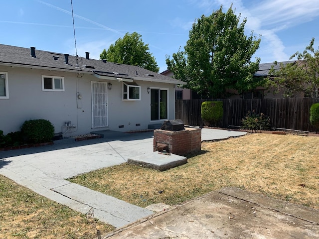 rear view of property with a yard and a patio