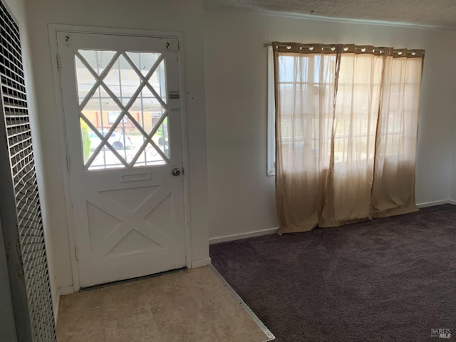 entryway featuring carpet floors and a textured ceiling