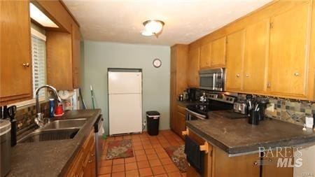 kitchen with electric range oven, tile floors, sink, and backsplash