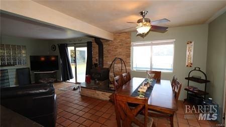 dining area with a healthy amount of sunlight, brick wall, ceiling fan, and tile floors