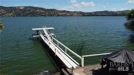 view of dock with a water and mountain view