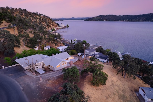 aerial view at dusk featuring a water view