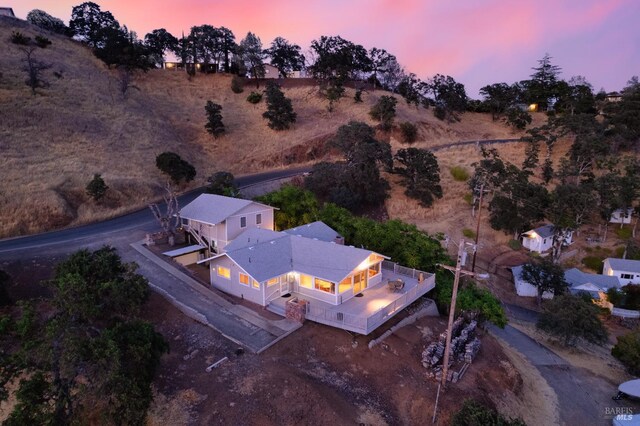 back house at dusk with a wooden deck