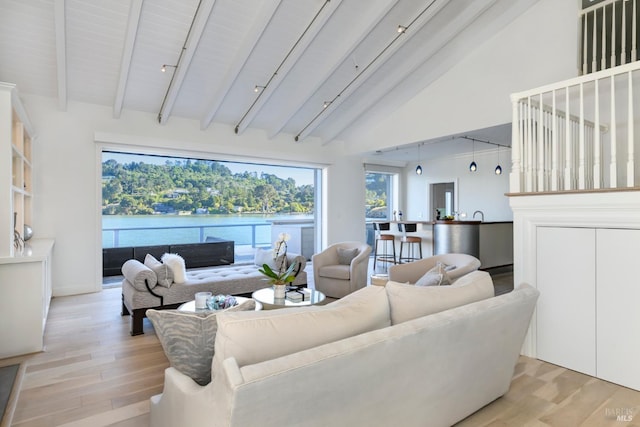 living room featuring light wood-type flooring, a water view, high vaulted ceiling, and beamed ceiling