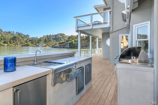 wooden deck featuring exterior kitchen and a water view