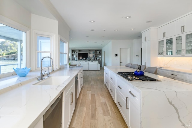 kitchen featuring white cabinets, sink, light stone counters, and stainless steel appliances