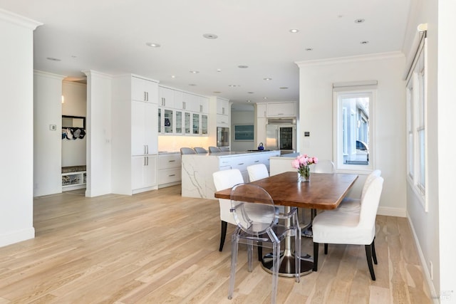 dining room featuring light hardwood / wood-style flooring and ornamental molding