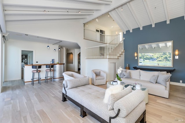 living room featuring beam ceiling, high vaulted ceiling, bar area, and light hardwood / wood-style floors