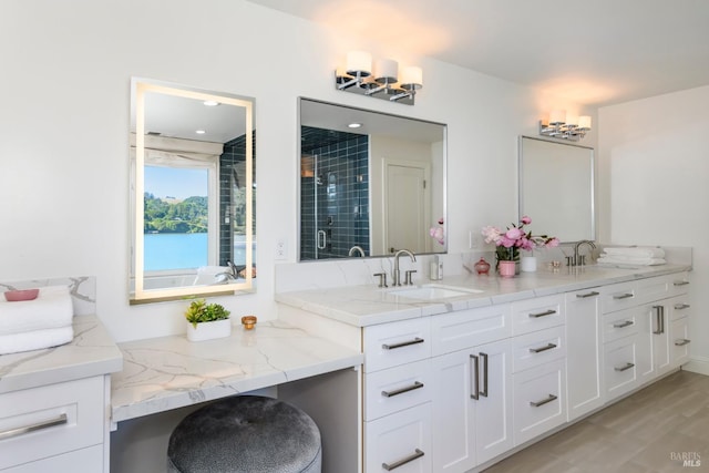 bathroom with wood-type flooring, vanity, and an enclosed shower