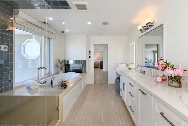 bathroom featuring vanity and shower with separate bathtub