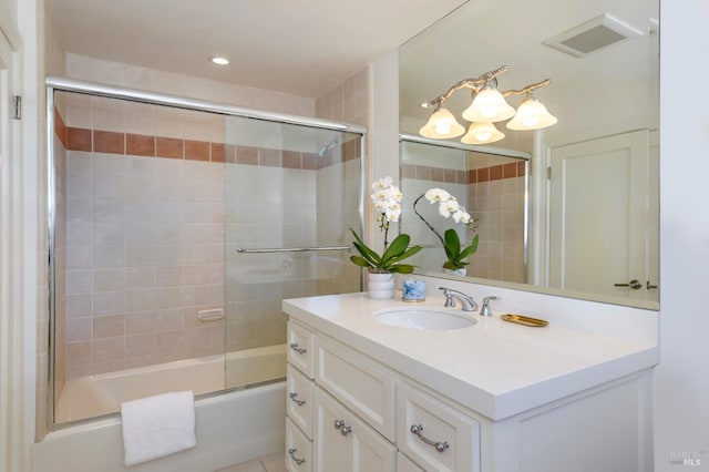 bathroom featuring enclosed tub / shower combo and vanity