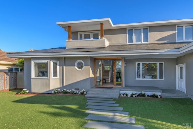 view of front facade featuring a balcony and a front yard