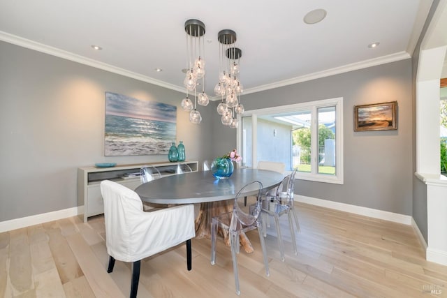 dining space with light wood-type flooring, crown molding, and a notable chandelier