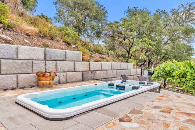 view of pool with an outdoor hot tub and a patio area